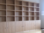 Großer, wandfüllender Bücherschrank mit offenen Regalen oben und geschlossenen Türen im unteren Bereich