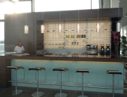 Bar mit dunkler Arbeitsplatte, Rückwandregalen und warmen Holzelementen im modernen Stil
