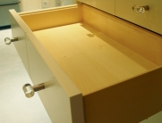 Holzschublade mit weißen Fronten und modernen Glasgriffen – elegantes und funktionales Design