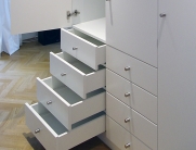 Weißer Schrank mit Schubladen – glatte, strukturlose Fronten und matte silberne Griffe für ein modernes Erscheinungsbild.